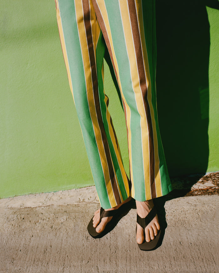 Pasha Trouser in green/yellow/brown striped cotton-linen and Chase Brown Flip Flop.