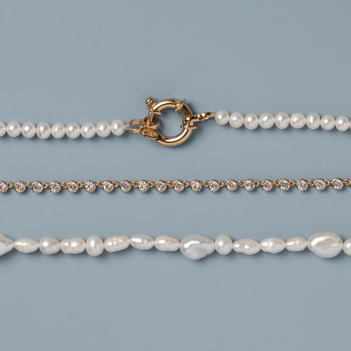 Model. Two pearl necklaces on a light blue background