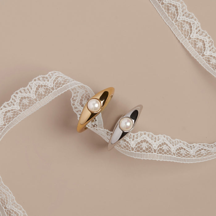 Model Gold rings with pearls on a beige background with lace