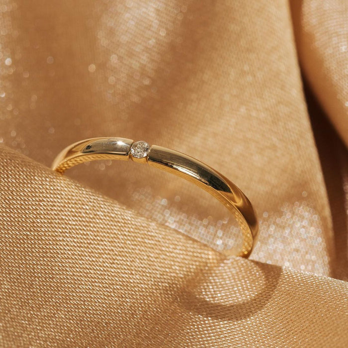 Diamond Tension Ring Flatlay Model. Close up of gold diamond ring on gold background