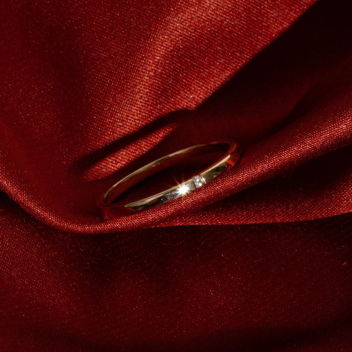 Lifestyle Model. Close up of gold diamond ring on red background