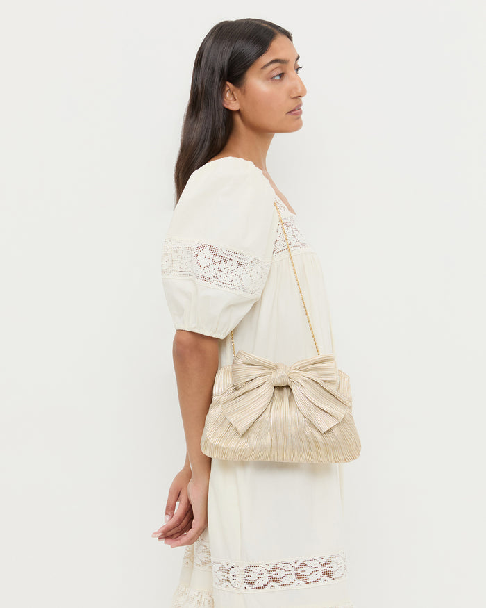 Rayne Platinum Bow Clutch in platinum champagne lamé and Jo Dress.