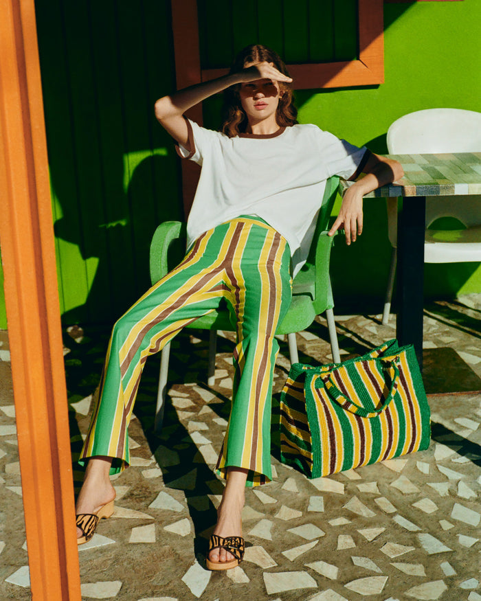 Harly Tee in white cotton, Pasha Trouser in green/yellow/brown striped cotton-linen, Paulie Zebra Studded Sandal, and Sol Green/Yellow Crochet Beach Tote - Loeffler Randall