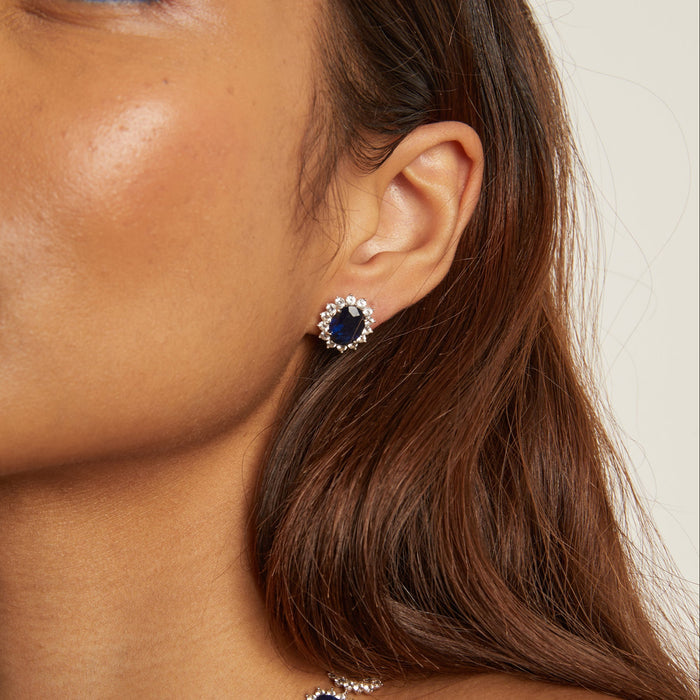 Model. Close-up of a woman wearing a necklace and earrings with blue gemstones.