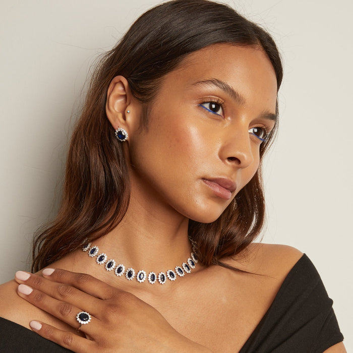 Model. Woman wearing a black off-shoulder top and necklace against a plain background