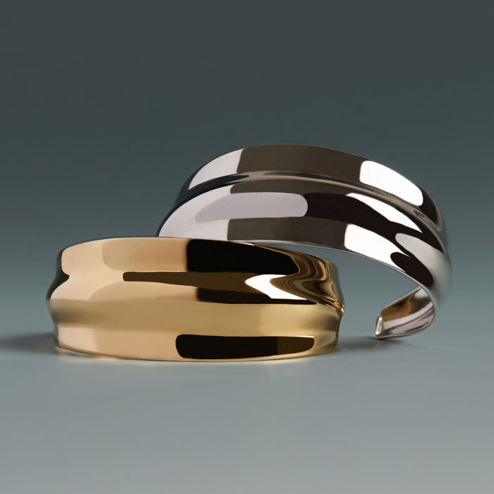 Model. Gold and silver rings on a gradient gray background