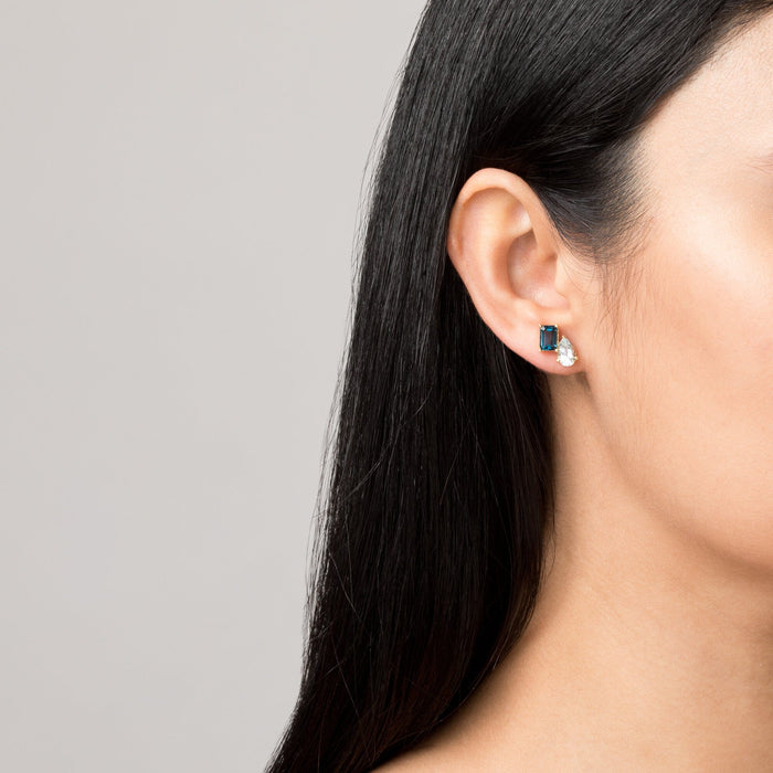Model. Close-up of a person wearing a pair of earrings with a gray background