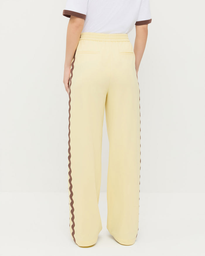 Venus Track Pant in butter yellow nylon, Harly Tee in white cotton, and Raina Dark Brown Mesh Flat.