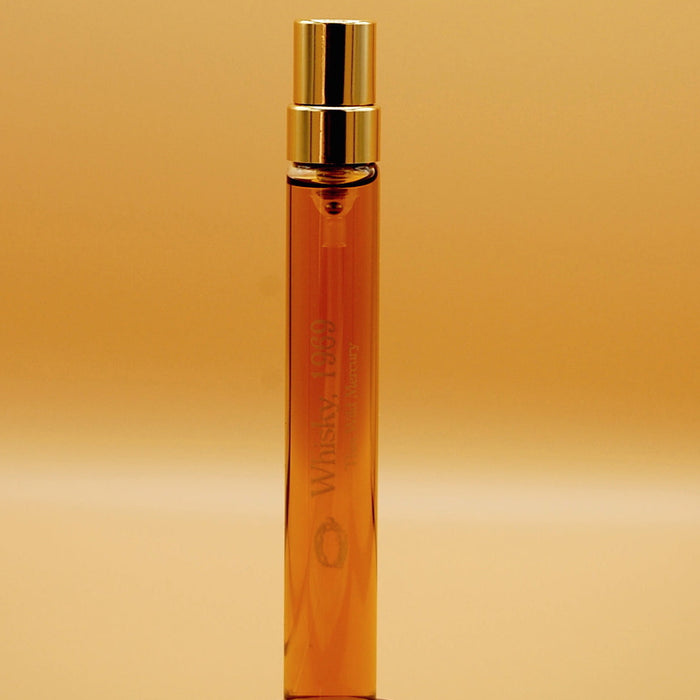 A tall, 8ml perfume vial with a gold-colored cap, that says "Whisky, 1969" printed in gold