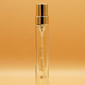 A clear glass 8ml travel sprayer with a gold cap, labeled 'Zuma, 1975'